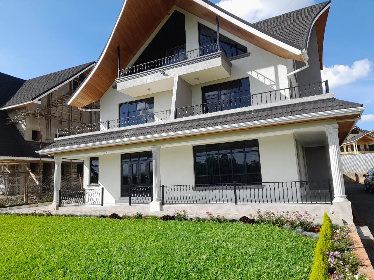 Daykio Bustani — white three-storey house with manicured lawn in Ruiru