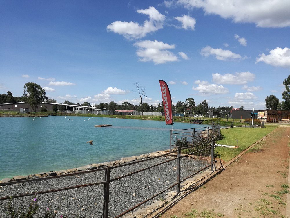 The lake at The Waterfront Karen — calm water against the campus lawns